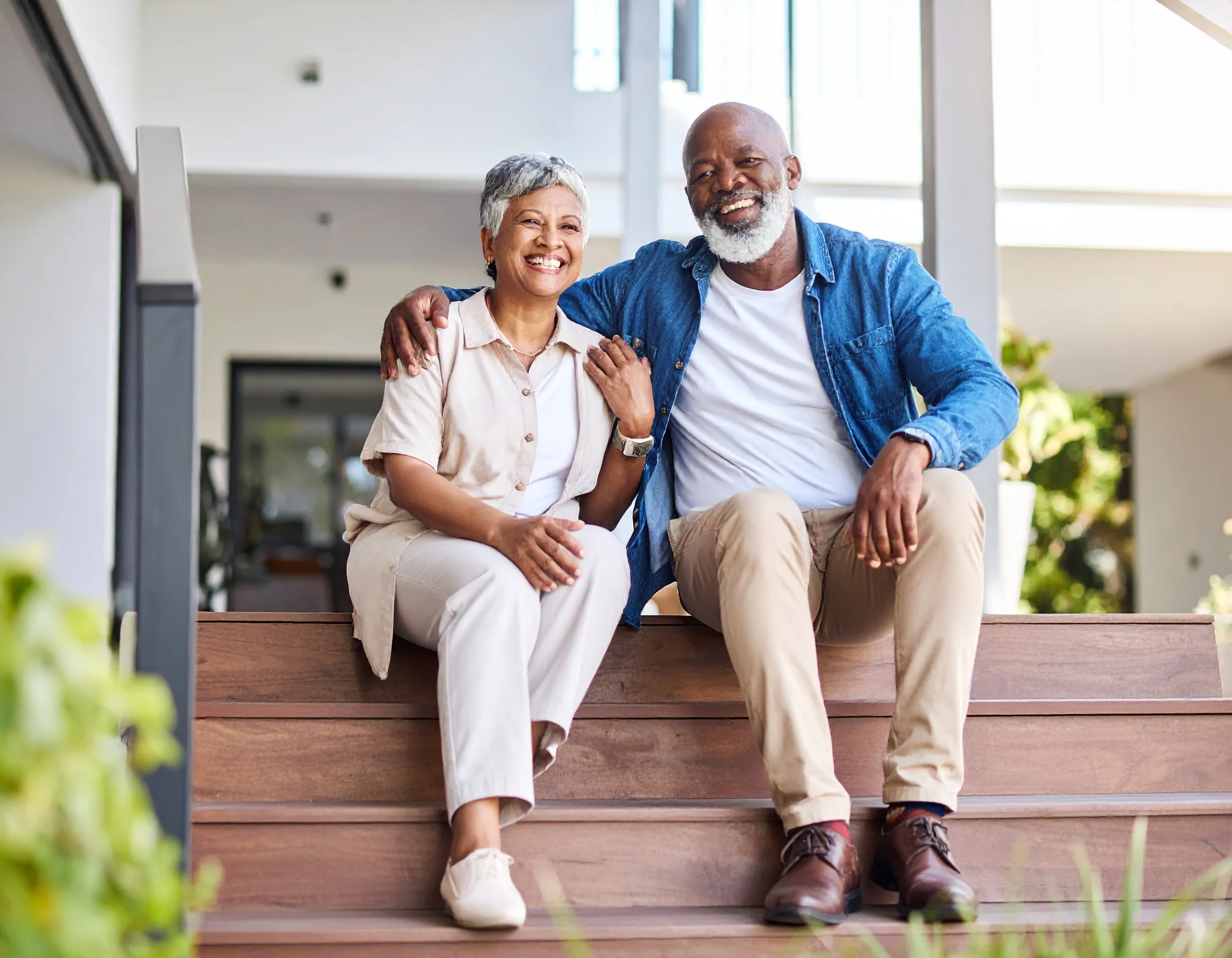 an image of an older couple, smiling on some porch steps.